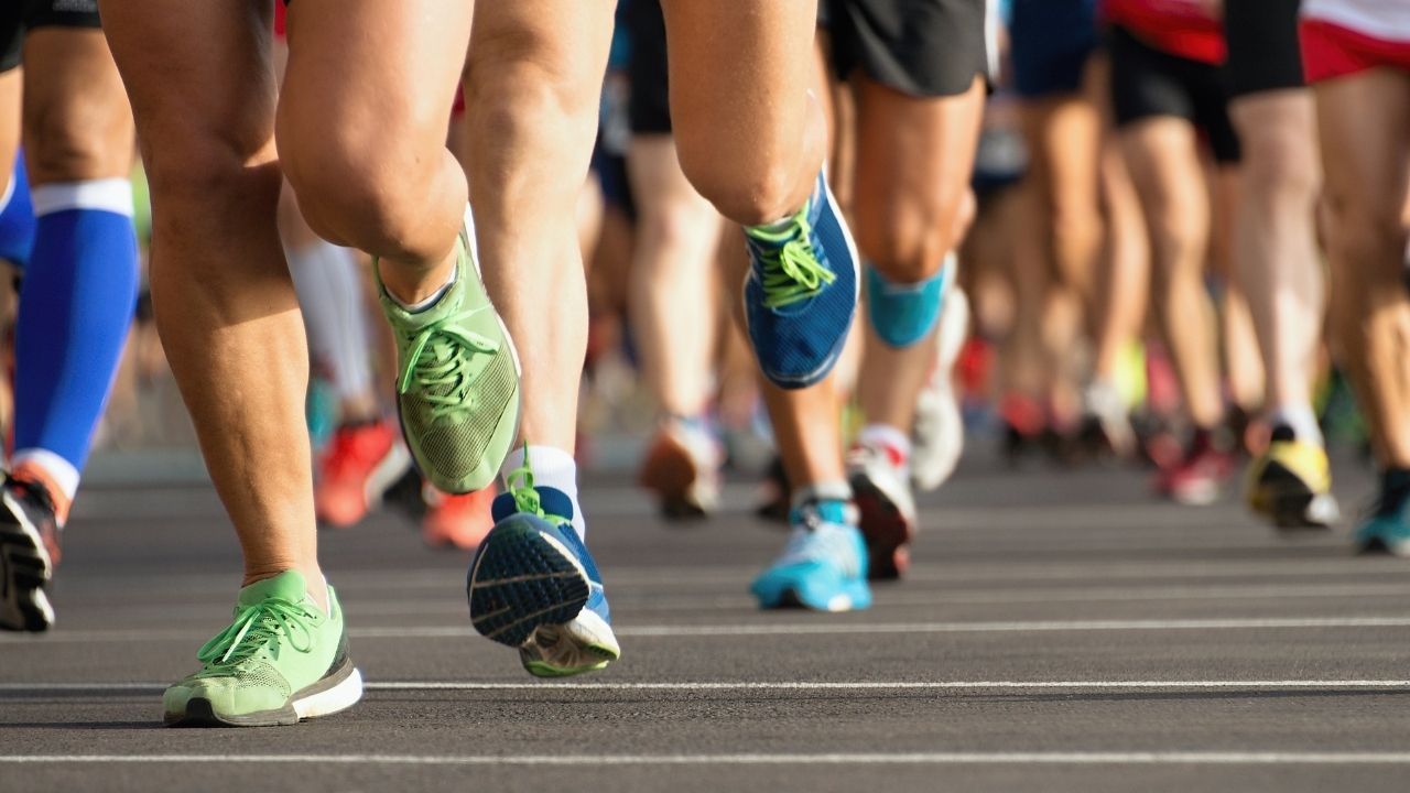 Race-day pacing strategy for a beginner half marathon Group of runners seen from a distance at the start of a half marathon race